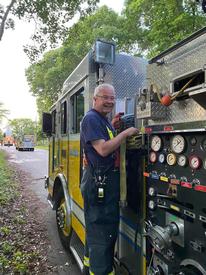 Rev. Lord packing hose on a Watch Hill engine during training while serving as a firefighter and department chaplain. 